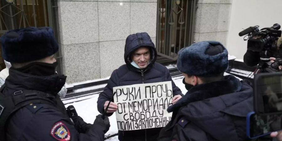Ein Demonstrant im Beisein der Polizei, der Mitte Dezember in Moskau gegen die gerichtliche Verfügung protestiert. Foto: Pavel Golovkin/AP/dpa