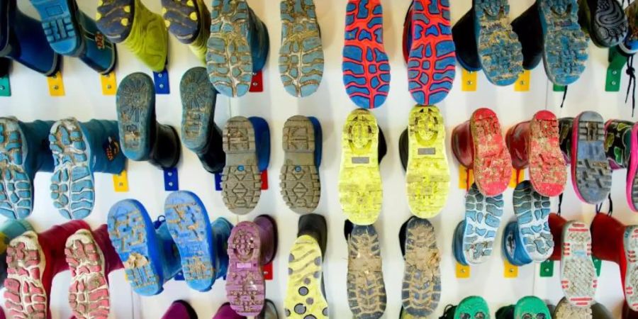 Gummistiefel hängen in einer Kindertageseinrichtung an einer Wand. In Deutschland fehlen einem Bericht zufolge nach wie vor viele Kitaplätze. Foto: Rolf Vennenbernd/ dpa