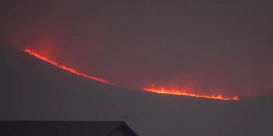 Riesige Flammen steigen über einem Bergkamm auf. Foto: David Zalubowski/AP/dpa