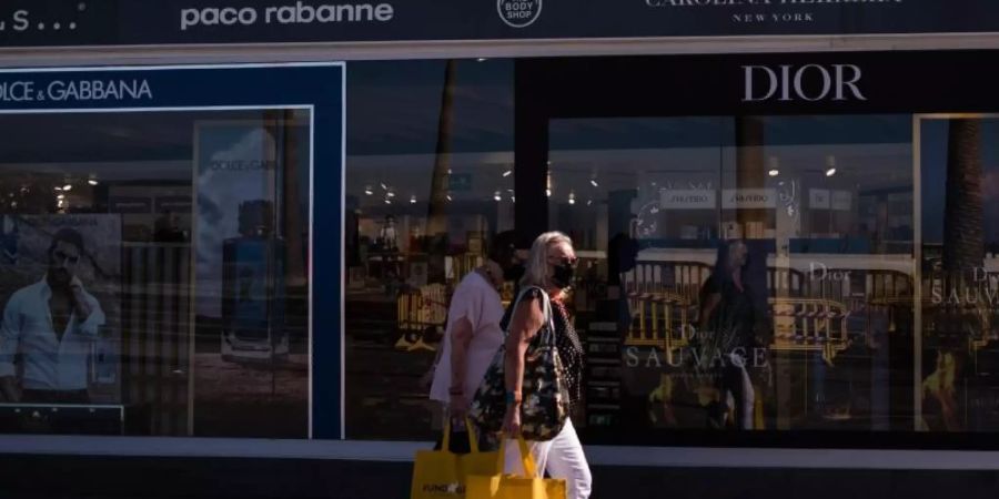 Zwei Frauen mit Mundschutz gehen in der Nähe von Playa Martinez in Santa Cruz de Tenerife shoppen. Auf den Kanarischen Inseln ist ein neuer Rekord an Neuinfektionen registriert worden. Foto: Arturo Jimenez/dpa