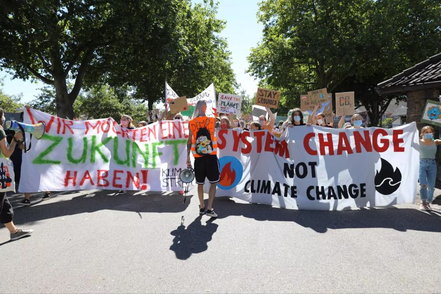 Teilnehmer des Klimastreiks halten Plakate hoch.