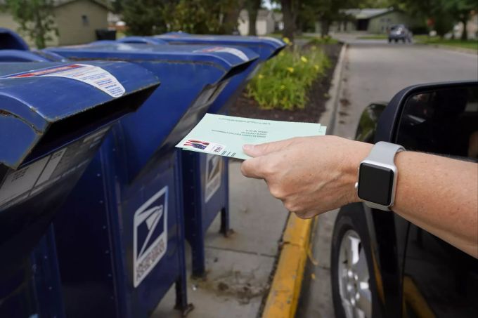 Eine Person wirft einen Brief in den Briefkasten der Election 2020 Postal Service