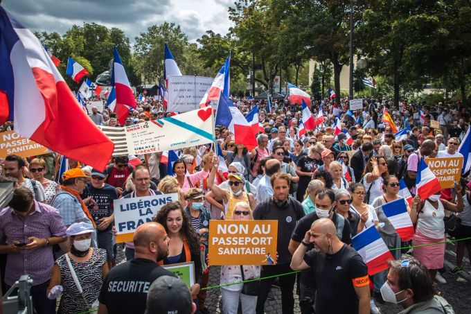 epa09423301 Protesters waves French flags and posters reading 'No the Health Pass' during a demonstration held by right-wing party 'Les Patriotes' against the COVID-19 sanitary pass which grants vaccinated individuals greater ease of access to venues, in Paris, France, 21 August 2021. For the fifth consecutive week, thousands of French demonstrators have taken to the streets in several cities across the country to protest against measures to curb the spread of coronavirus. EPA/CHRISTOPHE PETIT TESSON Right-wing party 'Les Patriotes' lead an Anti Health pass demonstration in Paris