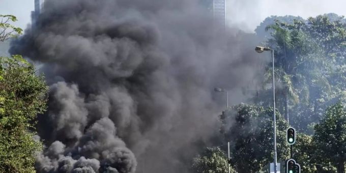 Plünderer stehen in Durban vor einem Einkaufszentrum neben einer brennenden Barrikade. Foto: Andre Swart/AP/dpa Plünderer stehen in Durban vor einem Einkaufszentrum neben einer brennenden Barrikade. Foto: Andre Swart/AP/dpa