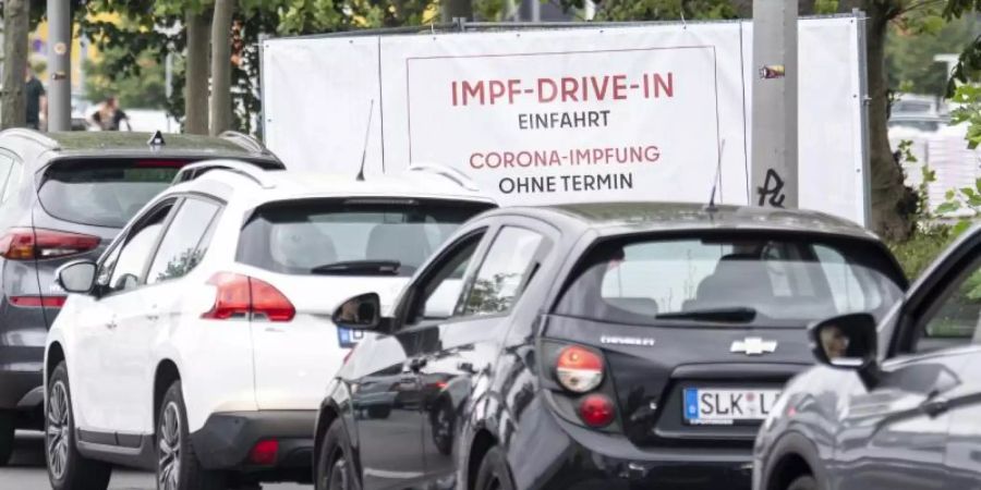 Eine lange Schlange bildet sich vor der Einfahrt zur Impfung an der Ikea-Filiale Lichtenberg vor dem Schild mit der Aufschrift "Impf-Drive-In Einfahrt Corona-Impfung Ohne Termin". Foto: Fabian Sommer/dpa