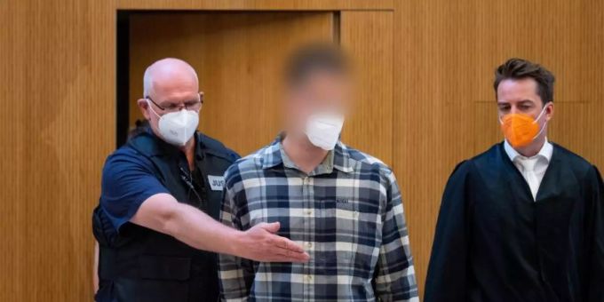 Einer der beiden wegen Mordes angeklagten Männer (M) wird in den Sitzungssaal geführt. Foto: Sven Hoppe/dpa Einer der beiden wegen Mordes angeklagten Männer (M) wird in den Sitzungssaal geführt. Foto: Sven Hoppe/dpa