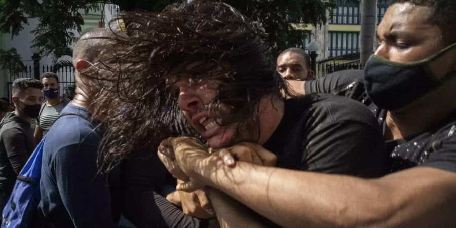 Polizisten in Zivil halten einen regierungskritischen Demonstranten während einer Demonstration in Havanna, Kuba, fest.