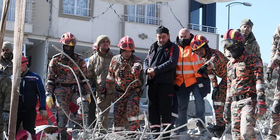 Einsatzkräfte suchen in den Trümmern nach Überlebenden. Foto: Hairul/BERNAMA/dpa