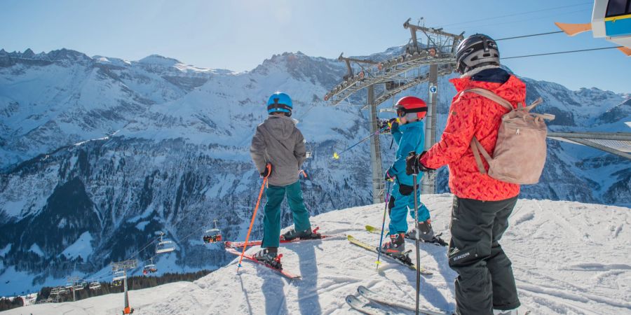 Eine Familie beim Skifahren an einem sonnigen Wintertag. (Symbolbild)