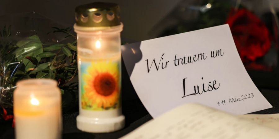 Ein Kondolenzbuch für die getötete Luise (†12) liegt neben Blumen und Kerzen in einer Kirche in Freudenberg aus.