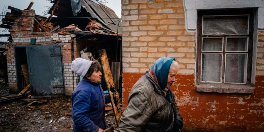 Frauen vor beschädigtem Haus bei Bachmut