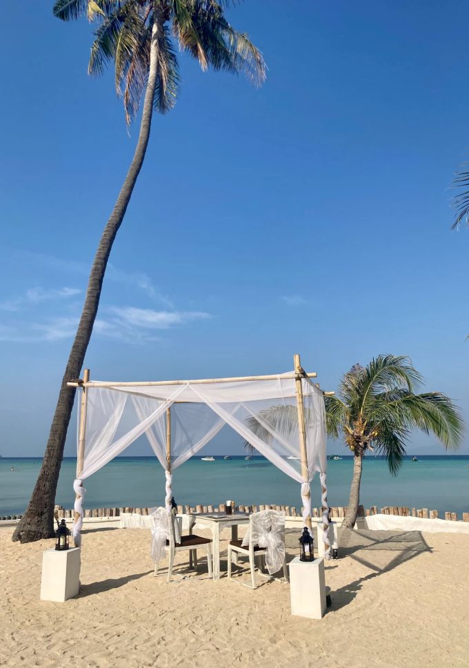 Was für ein Sitzplatz in einem Restaurant in der Loh Ba Kao Bay. Noch haben Touristen die meisten Traumstrände des Archipels für sich. Strand Tisch Stühle Schatten Meer Palme