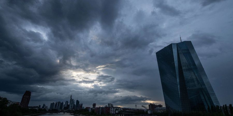 Dunkle Regenwolken ziehen über die Bankenskyline von Frankfurt am Main und die EZB hinweg.