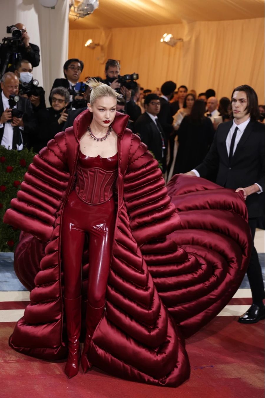 Das US-Model Gigi Hadid trägt einen pompösen Daunenmantel über einem Korsett von Versace.