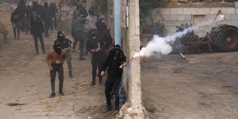 Eine Gruppe maskierter Männer attackieren in Beit Ummar isrealische Soldaten mit Feuerwerkskörpern.