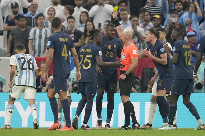 Schiri Szymon Marciniak zeigt Marcus Thuram Gelb wegen einer Schwalbe. WM 2022