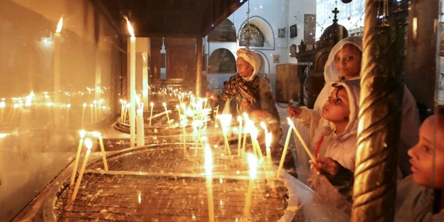 Pilger und Touristen entzünden Kerzen in Geburtskirche