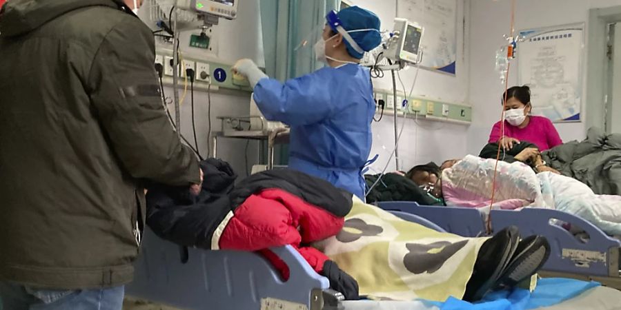 dpatopbilder - Patienten werden im Baoding No. 2 Central Krankenhaus behandelt. Von Null-Covid zu planloser Lockerung: Seit der Explosion der Corona-Fälle und dem abrupten Ende der rigorosen Null-Toleranz-Strategie in China vor zwei Wochen verbreitet sich das Virus mit hoher Geschwindigkeit im Milliardenvolk. Vielerorts sind die Krankenhäuser voll. Foto: Dake Kang/AP/dpa