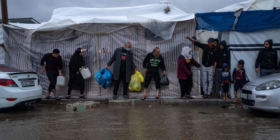 Palästinenser, die durch die israelische Bombardierung des Gazastreifens vertrieben wurden, suchen in einem Zeltlager der Vereinten Nationen in Chan Junis Schutz vor dem Winterregen.