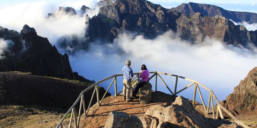 Ein Paar auf dem Berggipfel im Nebel.