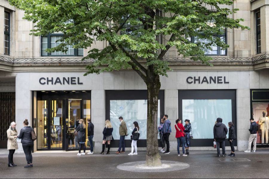 Kunden stehen vor dem Luxushändler Chanel Schlange.