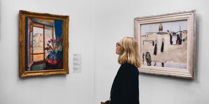 Eine Frau betrachtet Bilder in einer Ausstellung. (Symbolbild) Ausstellung