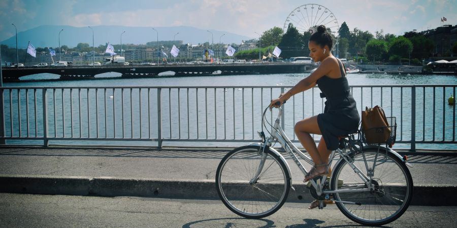 Frau auf dem Rad auf einer Brücke.