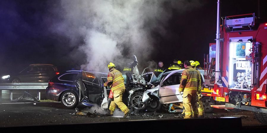 Hilfskräfte der Feuerwehr sind an der Unfallstelle beim Autobahnkreuz Hoevelaken östlich von Amsterdam im Einsatz.