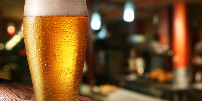 Ein angefeuchtetes Glas ermöglicht eine schöne Schaumkrone. Bierglas auf Theke