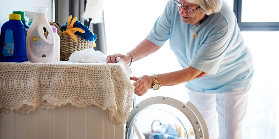 Seniorin an der Waschmaschine