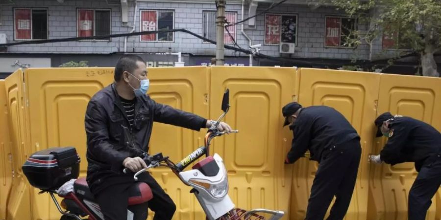 In der Stadt Wuhan werden Barrieren entfernt. Weil China offiziell kaum Neuinfektionen mit dem Coronavirus meldet, hebt es die Beschränkungen für die Bevölkerung allmählich auf. Foto: Ng Han Guan/AP/dpa