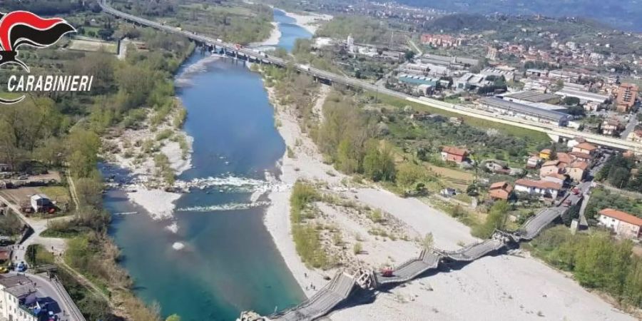 Die von der Polizei zur Verfügung gestellte Luftaufnahme zeigt die eingestürzte Brücke über einem Fluss. Foto: Carabinieri/dpa