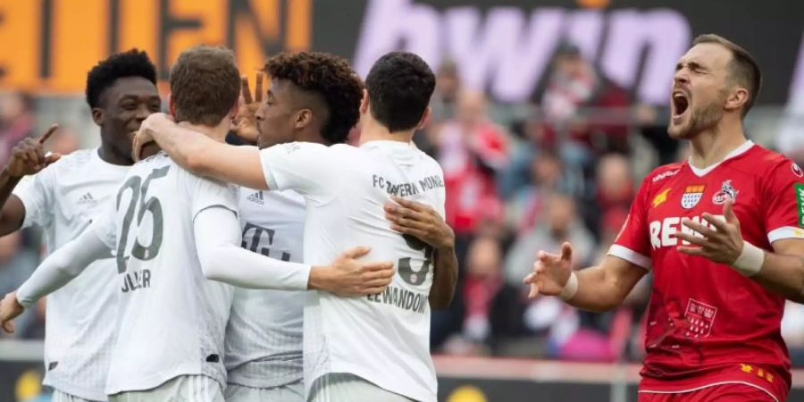 Bayerns Alaba (l-r), Müller, Coman und Lewandowski feiern das 2:0. Kölns Czichos (r) schreit und ärgert sich. Foto: Federico Gambarini/dpa