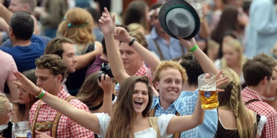 Wiesnbesucher feiern im Hofbräuzelt auf dem Oktoberfest. Foto: Andreas Gebert/dpa