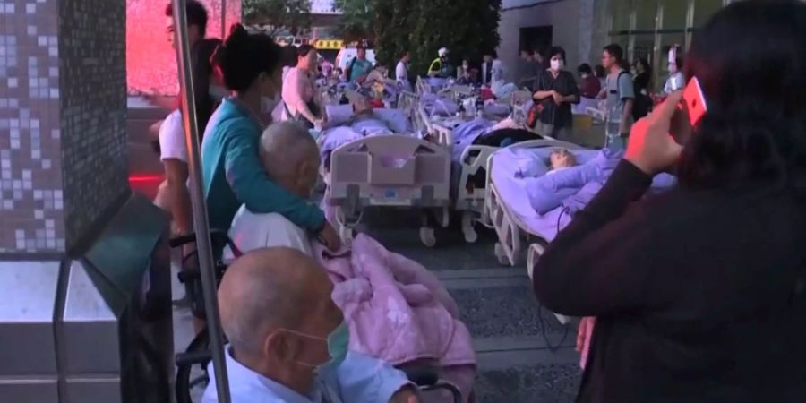 Das Videostandbild zeigt die geretteten Patienten des brennenden Spitals ausserhalb der Klinik im Norden Taiwans.