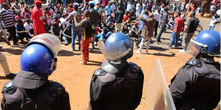 Polizisten halten Anhänger der Oppositionspartei MDC davor auf, in das Hauptquartier der Wahlkommission nach Bekanntgabe der ersten offiziellen Wahlergebnisse in Harare einzudringen.