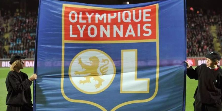 Zwei Kinder halten eine Fahne mit dem Wappen des französischen Fussballklubs Olympique Lyon.