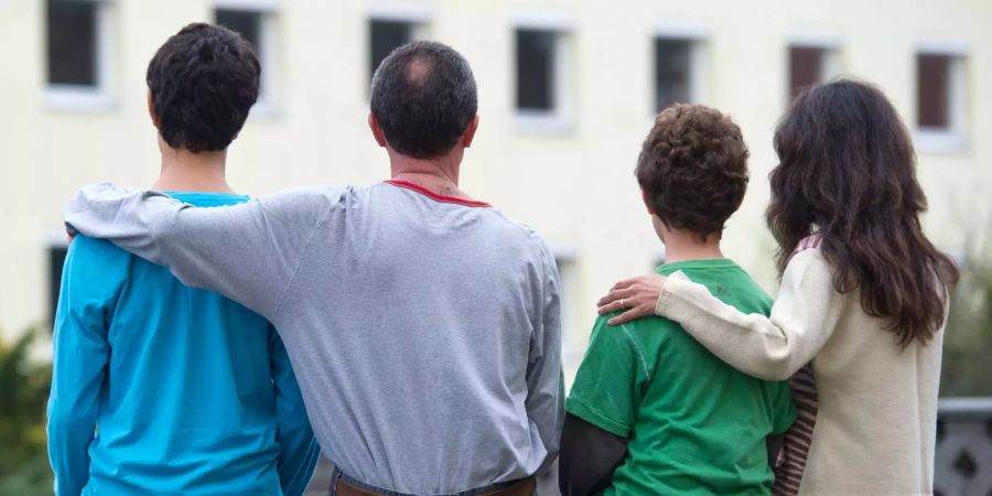 Eine syrische Familie sitzt vor einem Asylwohnheim der Zentralen Ausländerbehörde des Landes Brandenburg.