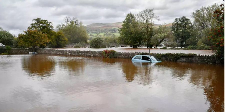 Ein Auto schwimmt im überschwemmten Wales.