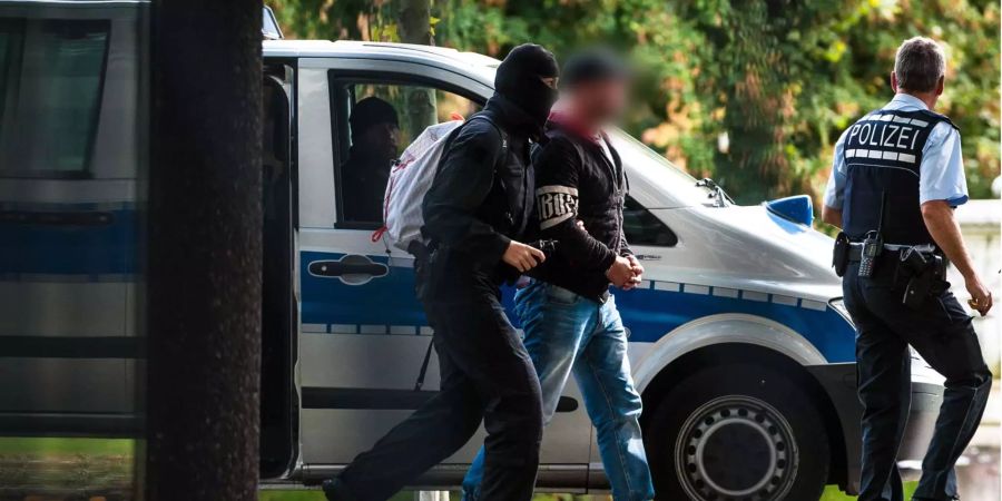 Mutmassliche Rechtsterroristen, die am Morgen in Bayern und Sachsen festgenommen wurden, erreichen den Bundesgerichtshof und werden von Polizisten abgeführt.