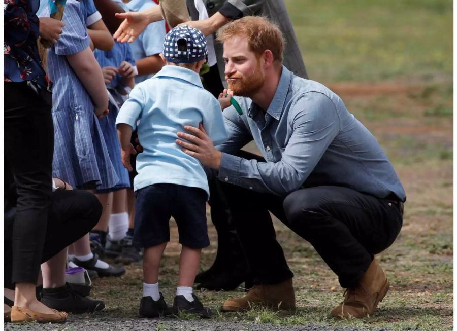 Prinz Harry wird vom kleinen Luke am Bart gekrault. Dieser nimmts mit viel Humor.