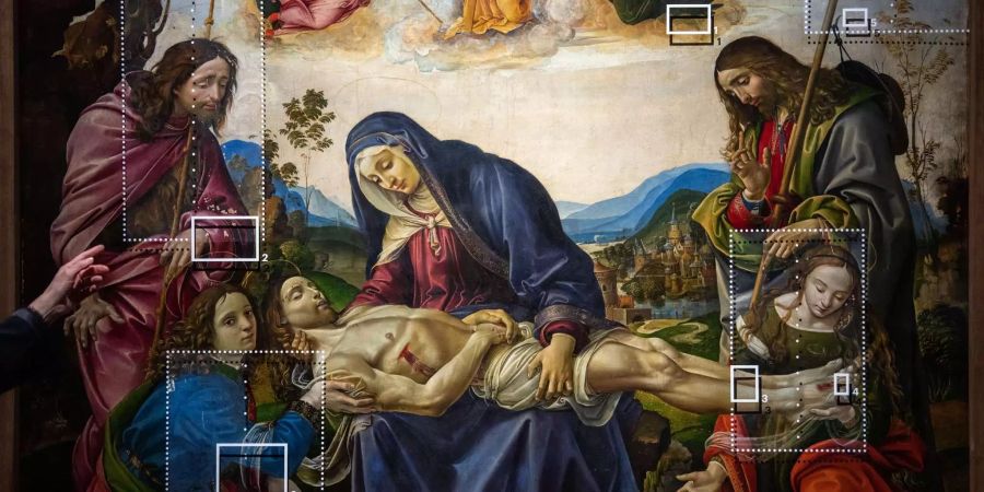 Eine Hand zeigt während eines Presserundgangs der Ausstellung «Florenz und seine Maler – Von Giotto bis Leonardo Da Vinci» auf das Bild «Beweinung Christi» von Raffaellino del Garbo, auf dem die Restaurationsstadien auf einer Glasscheibe vor dem Bild sichtbar gemacht wurden.