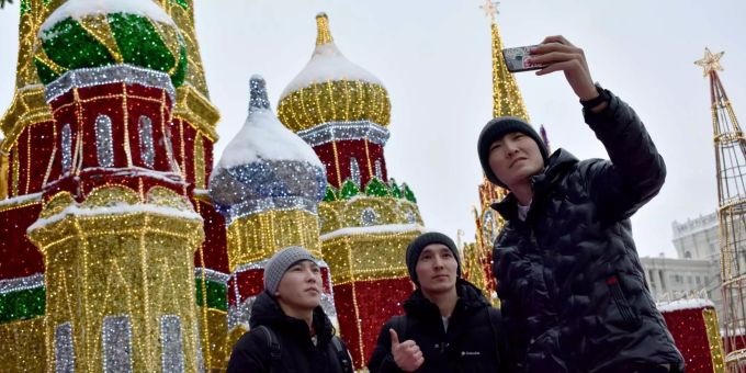 Bei winterlichem Wetter: Touristen machen ein Selfie vor der Kulisse des nachgebauten Kreml in Moskau. Schnee in Moskau