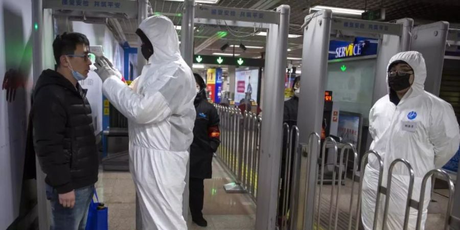 Temperaturkontrollen in einer U-Bahn-Station in Peking. Foto: Mark Schiefelbein/AP/dpa