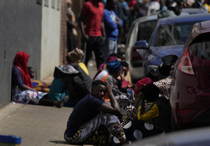 Anwohner des tödlichen Brandes sitzen am Donnerstag, 31. August 2023, in der Innenstadt von Johannesburg neben dem Gebäude, in dem sie wohnten. südafrika brand