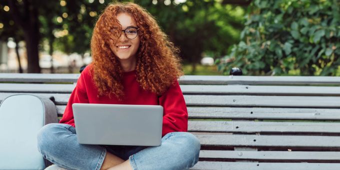 Je früher man mit Geld anlegen anfängt, desto besser. Man kann aber zu jedem Zeitpunkt noch damit beginnen. Junge Frau an Laptop