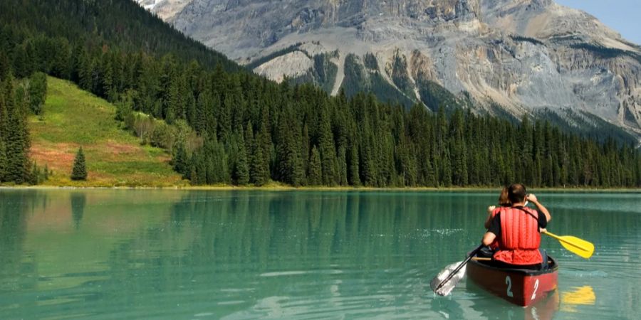 Pärchen Kanu fahren Bergsee Wald Berge