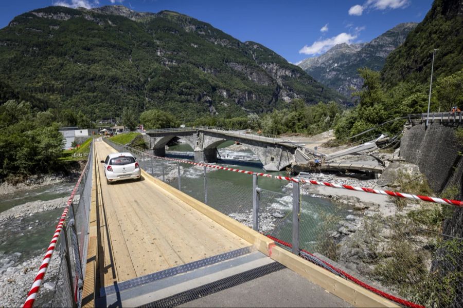 Nachdem die Verkehrsbrücke bei den Unwettern zerstört wurde, überqueren Autos nach Freigabe die Fussgängerbrücke zwischen Visletto und Cevio.