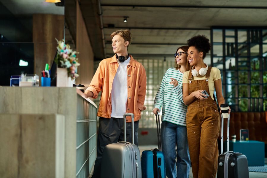 Mann und zwei Frauen, Freunde checken im Hotel ein