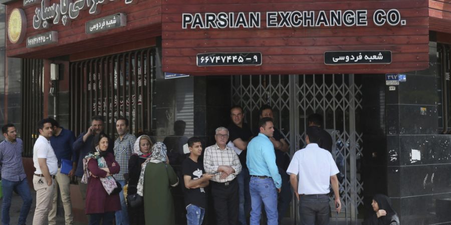 ARCHIV - Menschen stehen vor einer Wechselstube an, um US-Dollar und Euro zu kaufen. Der Iran steckt wegen der von den USA verhängten Sanktionen in einer akuten Währungskrise. Foto: E...